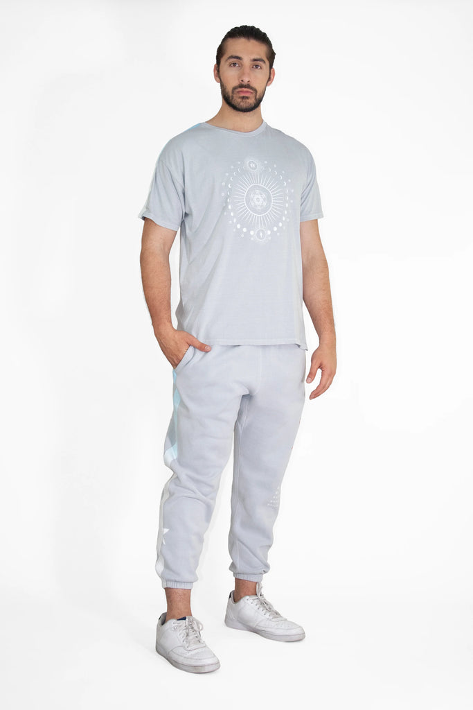 A man wearing a MOON METATRON TEE IN GALACTIC GRAY t-shirt and joggers.
