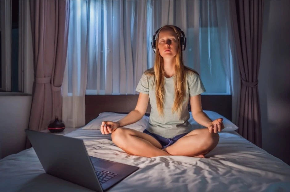 woman meditating while listening to headphones