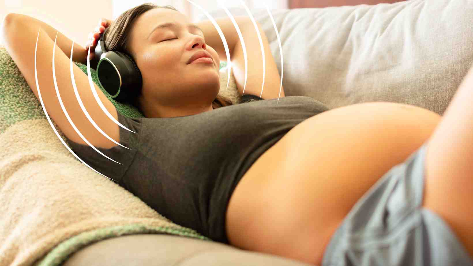 pregnant woman listening to music through headphones