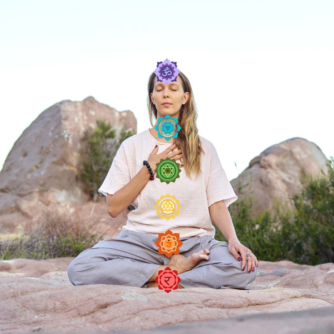 Person meditating outdoors with chakra symbols overlayed.