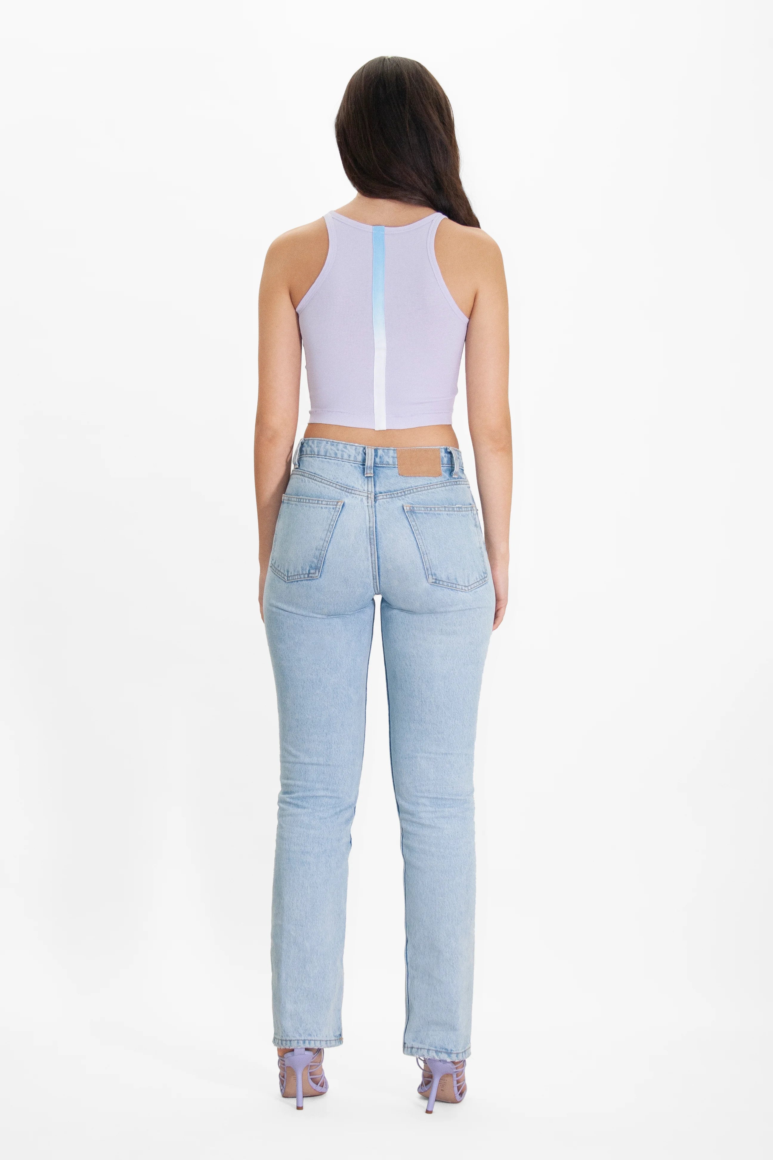 The back view of a woman wearing Angel Number 222 Cropped Tank in Nebula by GFLApparel jeans and a crop top.