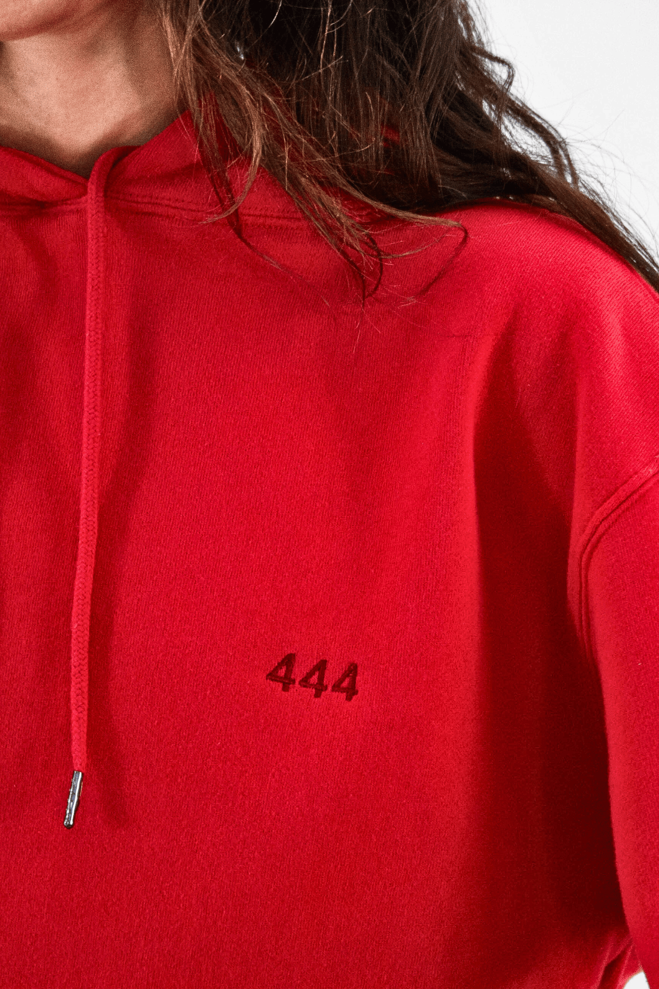 A close-up of a person in a GFLApparel Angel Number 444 Hoodie, symbolizing a spiritual journey with the number 