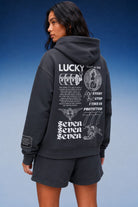 A model wearing an asteroid color hoodie and matching shorts, shown from the back. The hoodie features a large white graphic print on the back with the word 'LUCKY', 'SEVEN SEVEN SEVEN', and other illustrations.