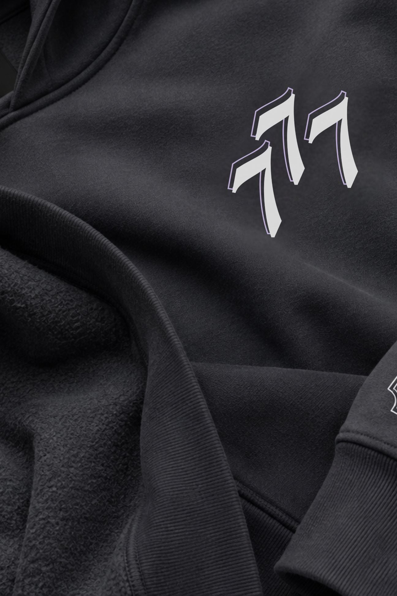 Close-up of a asteroid color fleece and cotton hoodie featuring a stylized white and gray 777 logo on the chest.