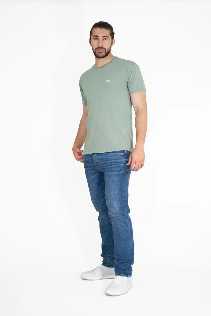 A man wearing Angel Number 1111 Tee in Sage by GFLApparel jeans and a green t - shirt.