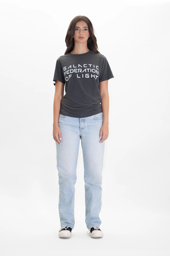 A woman wearing GFL STACK TEE IN SPACE GLOW jeans and a black t-shirt from GFLApparel.