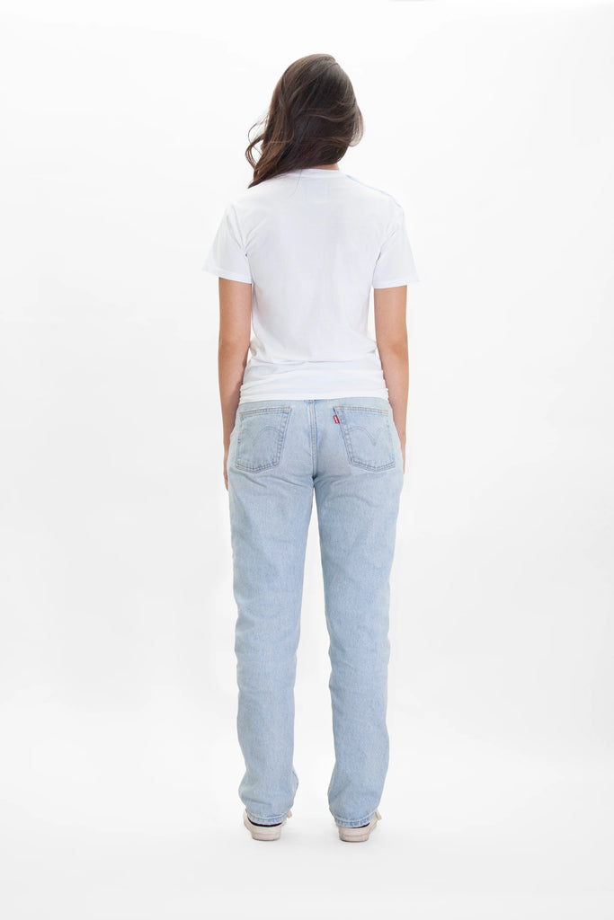 The back view of a woman wearing LIGHT WORKER TEE IN LITE BEAM by GFLApparel jeans and a white t - shirt.