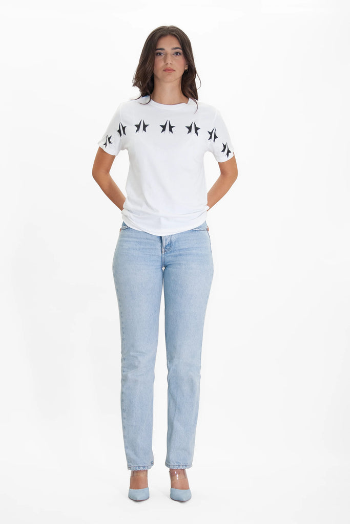 A woman wearing jeans and a GFL STARS TEE IN LITE BEAM by GFLApparel.