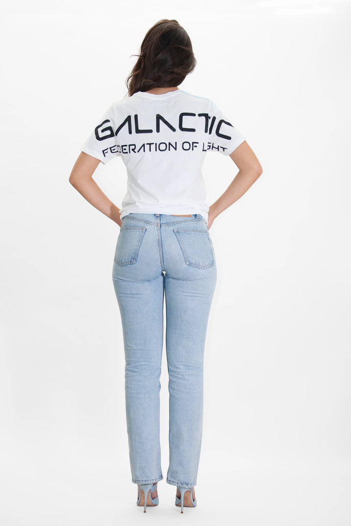 The back of a woman wearing GFL STARS TEE IN LITE BEAM jeans and a white t - shirt by GFLApparel.