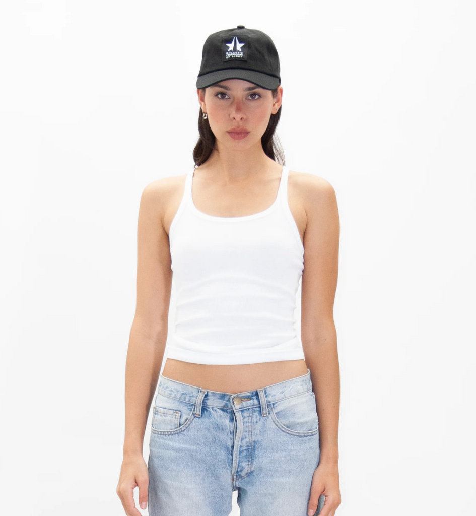 A woman wearing a white GFL BASEBALL CAP and jeans from GFLApparel.