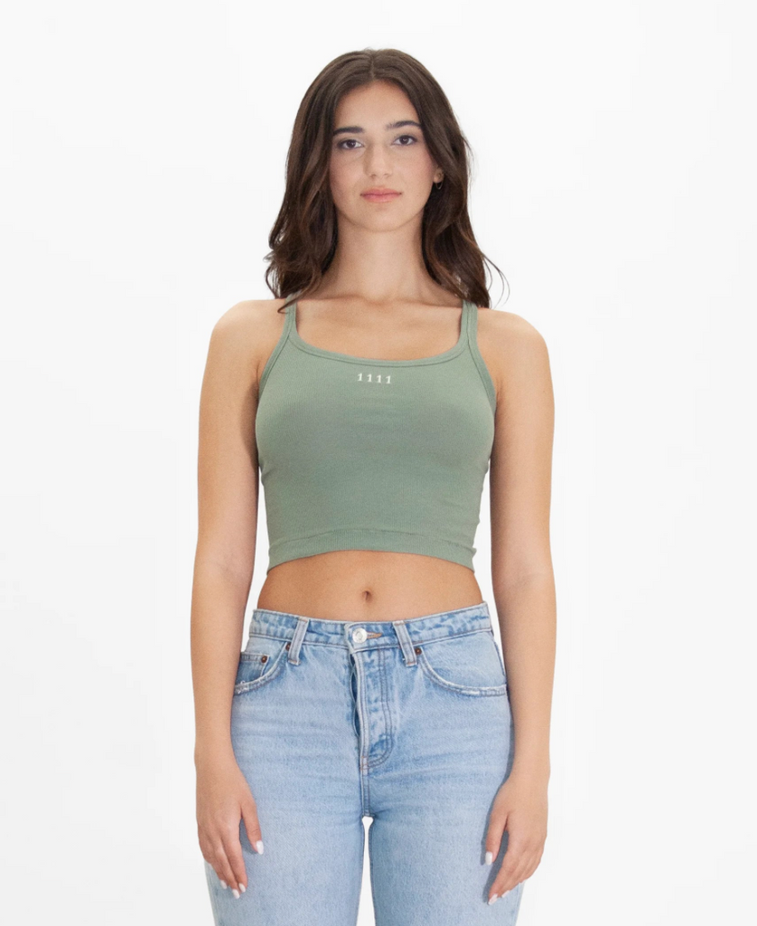A woman wearing a GFLApparel Angel Number 1111 Cropped Tank in Sage and jeans.