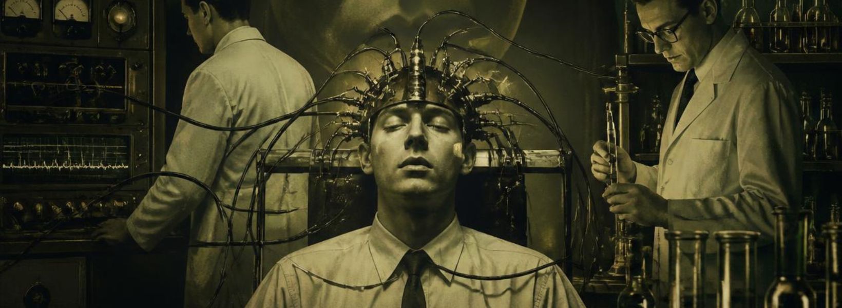 man in a chair with many wires coming out of a metal helmet on his head with scientists studying results in the background and brain waves