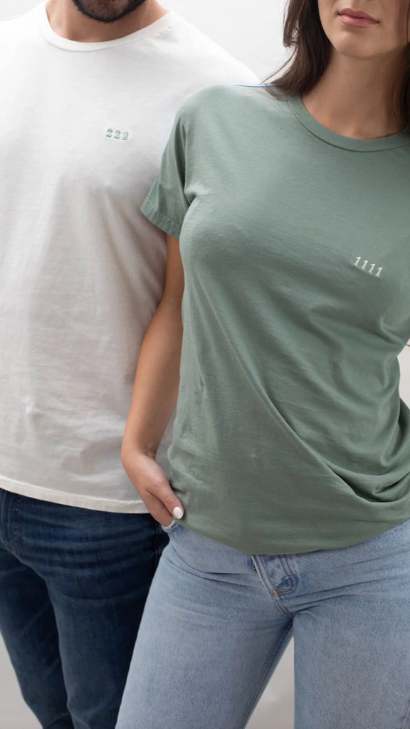 A man and woman standing next to each other wearing Angel Number 1111 Tee in Sage t-shirts from GFLApparel.