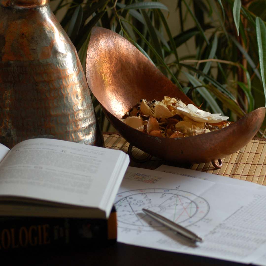 a desk with astrological chart and journal and potpourri
