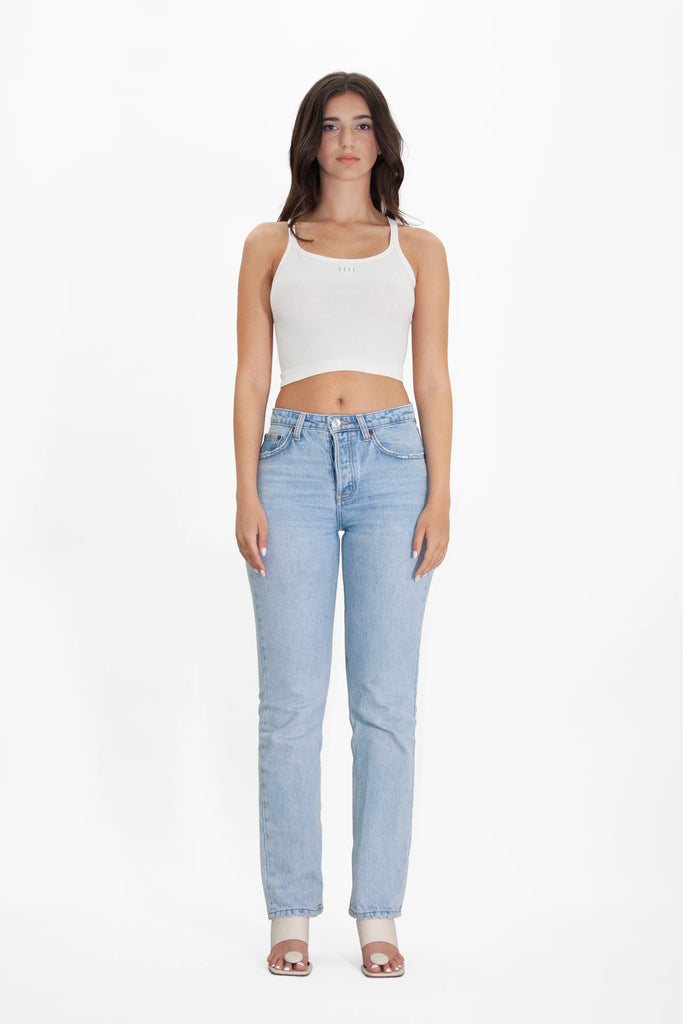 A woman wearing an Angel Number 1111 Cropped Tank in Bone from GFLApparel and jeans.