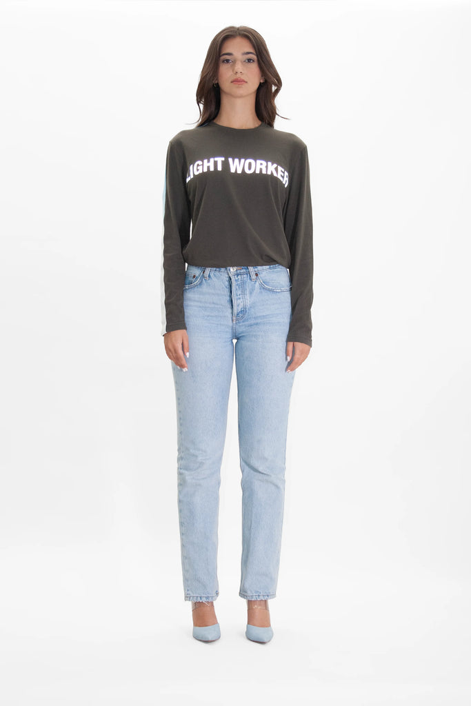 A woman wearing jeans and a t-shirt that says "don't worry" is wearing the LIGHT WORKER L/S IN CALADAN shirt by GFLApparel.