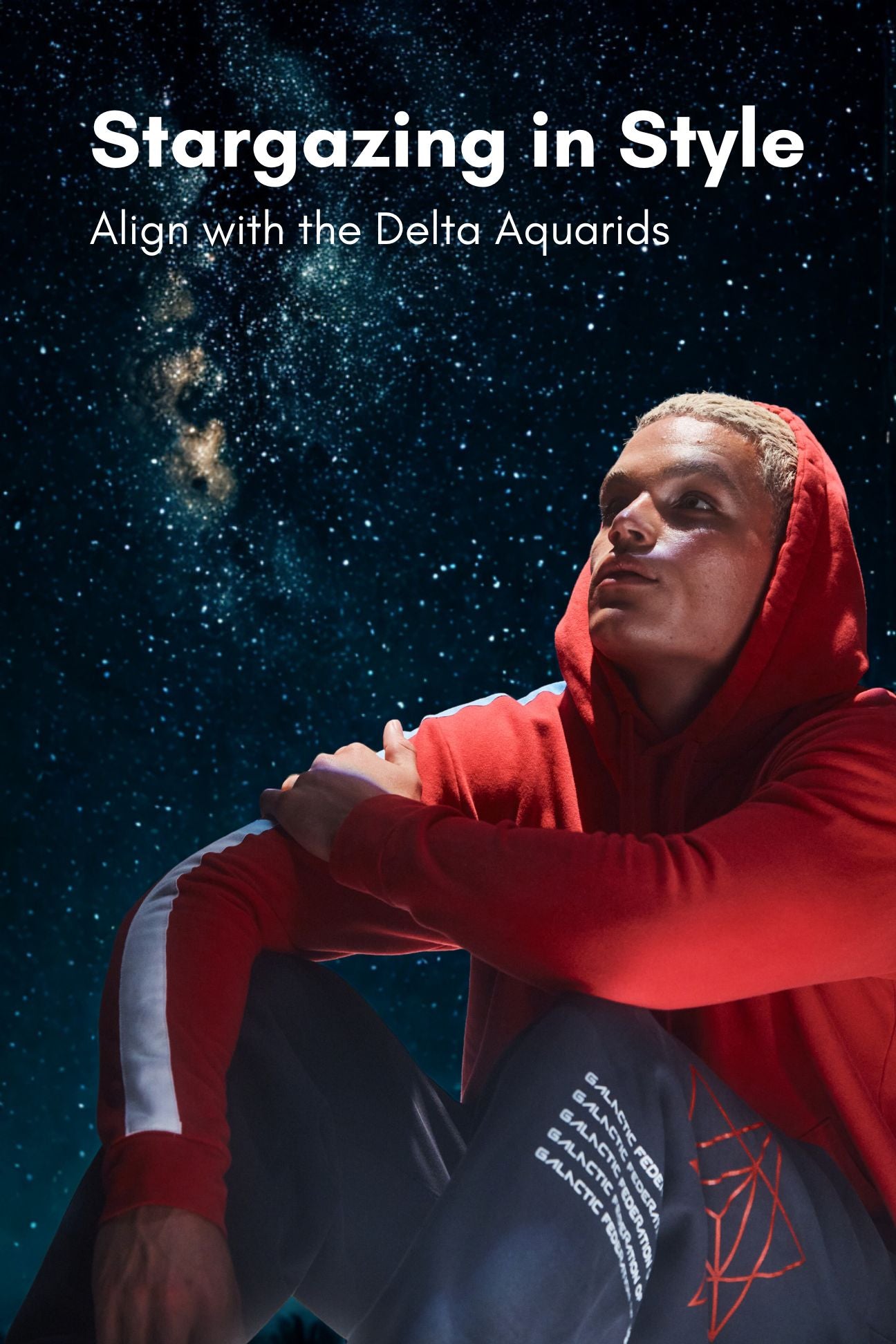a man watching the stars in a bright red hoodie