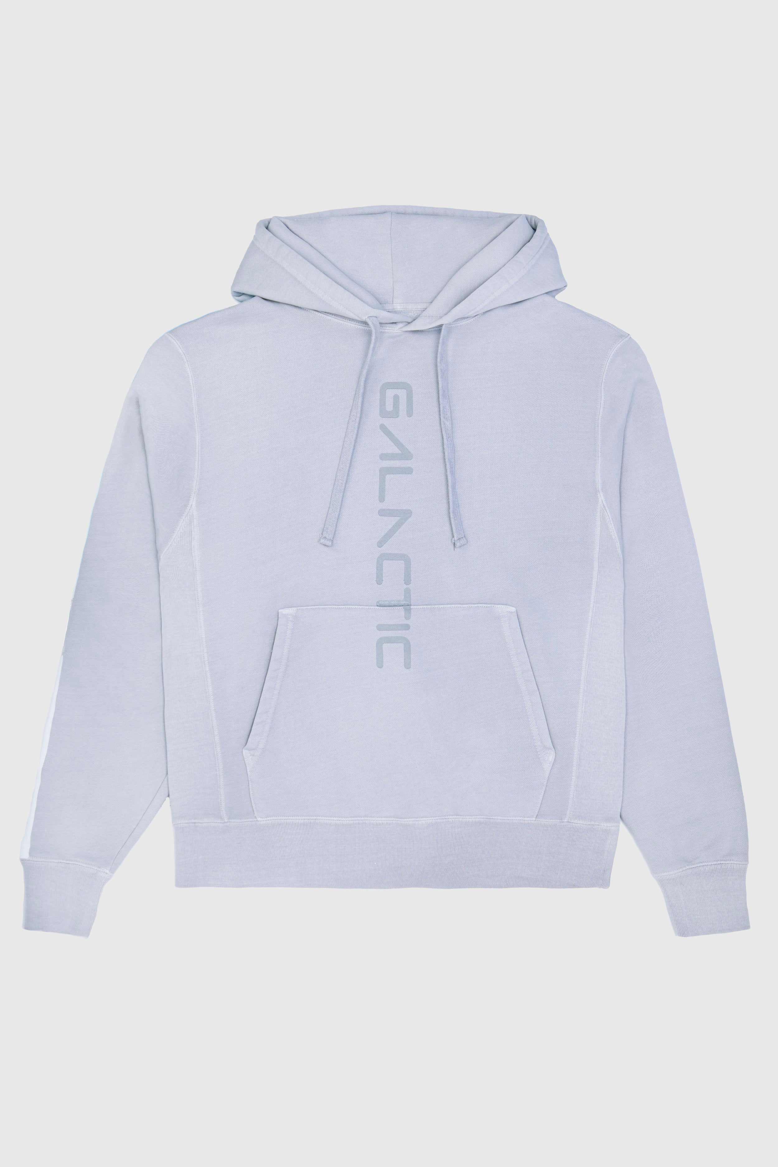 Light gray GFLApparel Hypergalactic Hoodie in Galactic Gray made from a heavyweight cotton blend, featuring a front pocket and the word "GALACTIC" printed vertically down the center. Handcrafted in LA for ultimate comfort and style.