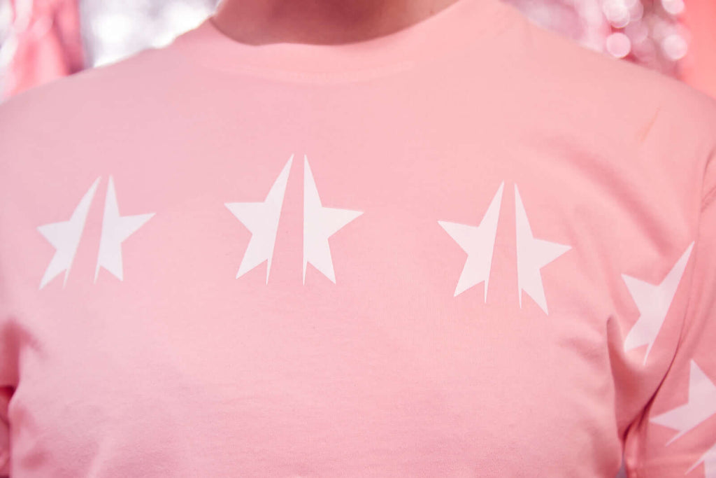 A woman wearing a GFL STARS TEE IN SUNFADE shirt with stars on it.
