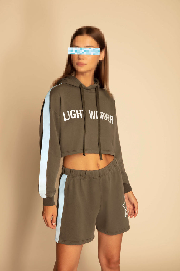 A woman wearing a grey and blue LIGHT WORKER CROPPED HOODIE IN CALADAN and shorts from GFLApparel.