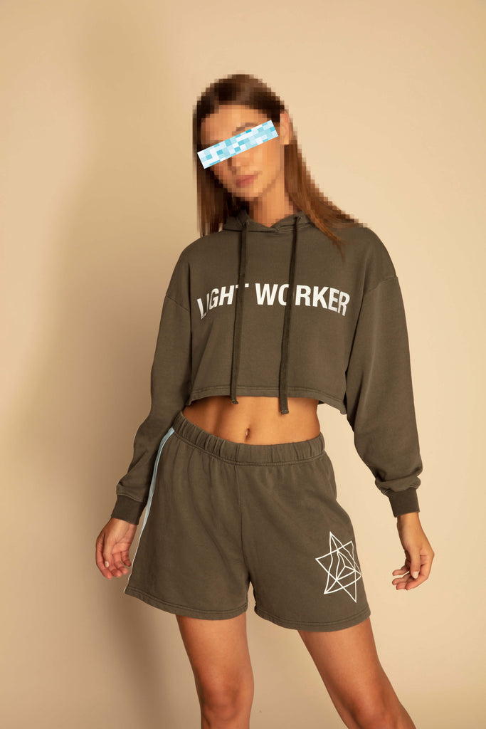A woman wearing a LIGHT WORKER CROPPED HOODIE IN CALADAN by GFLApparel and shorts.